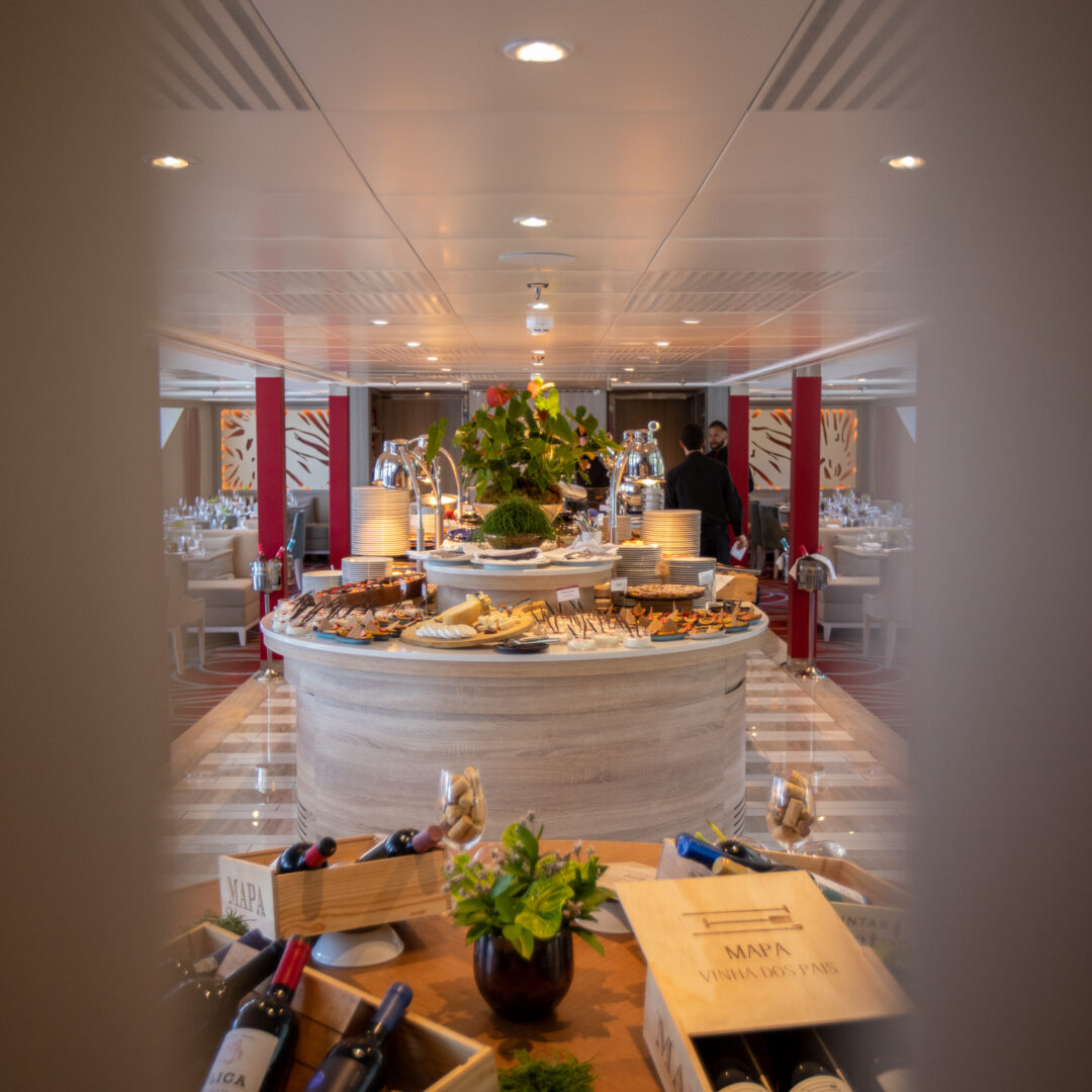 Elegante Restaurantansicht mit Buffet und dekorativen Weinen im Fokus auf Tischen.