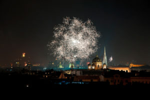 Silvesterfeuerwerk über der Wiener Innenstadt mit beleuchteten historischen Gebäuden bei Nacht