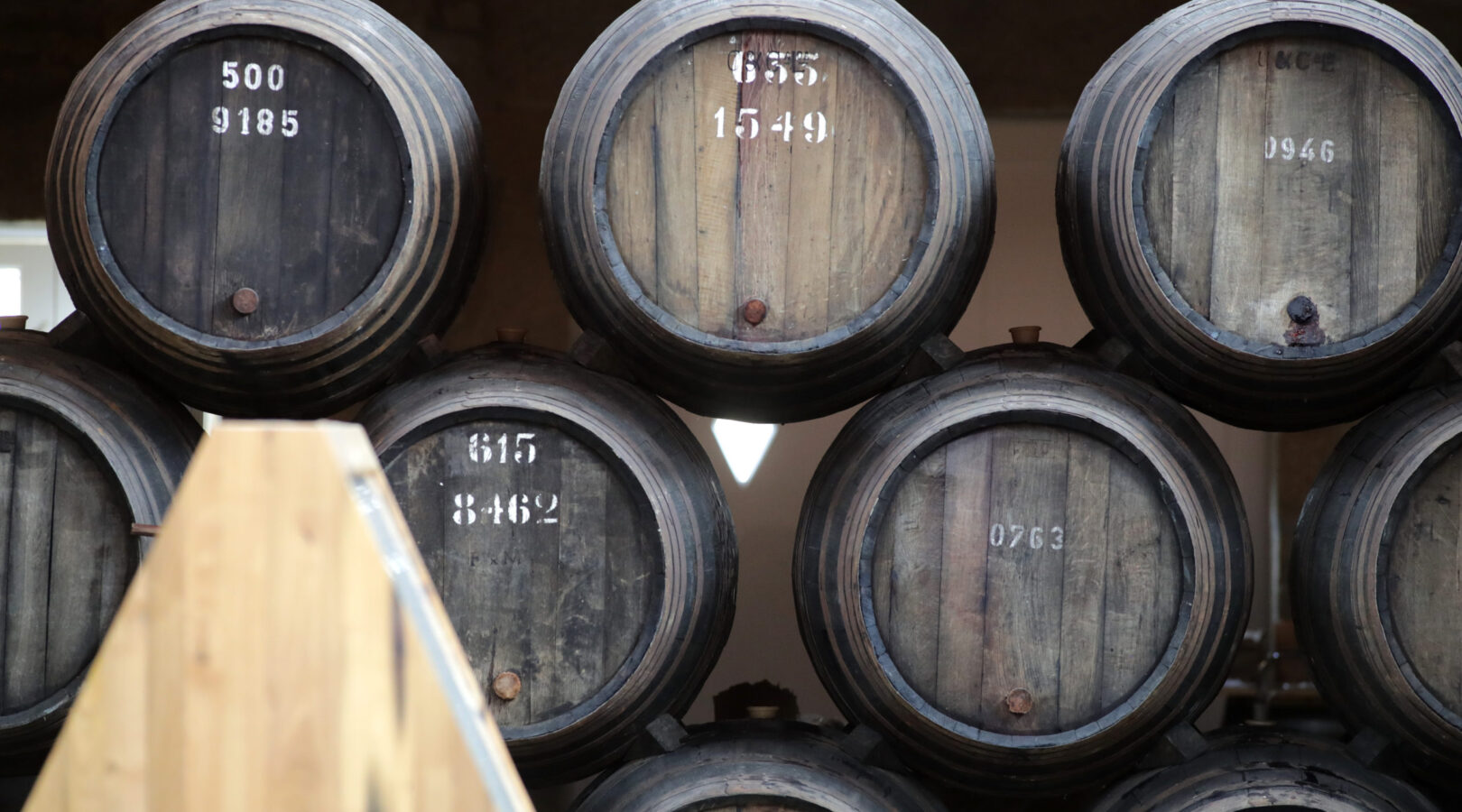 Holzfass mit weißen Nummern gestapelt in einem Lagerraum