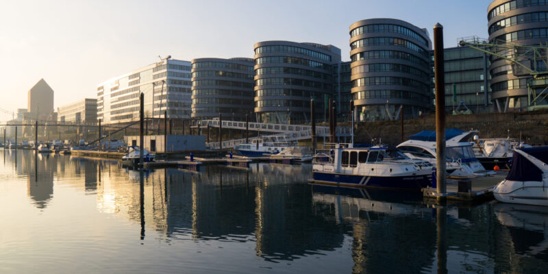 Marina am Innenhafen Duisburg mit festgemachten Booten, modernen Bürogebäuden und ruhiger Wasserfläche am Morgen.

Marina at Duisburg's inner harbour with moored boats, modern office buildings and calm waters in the morning.